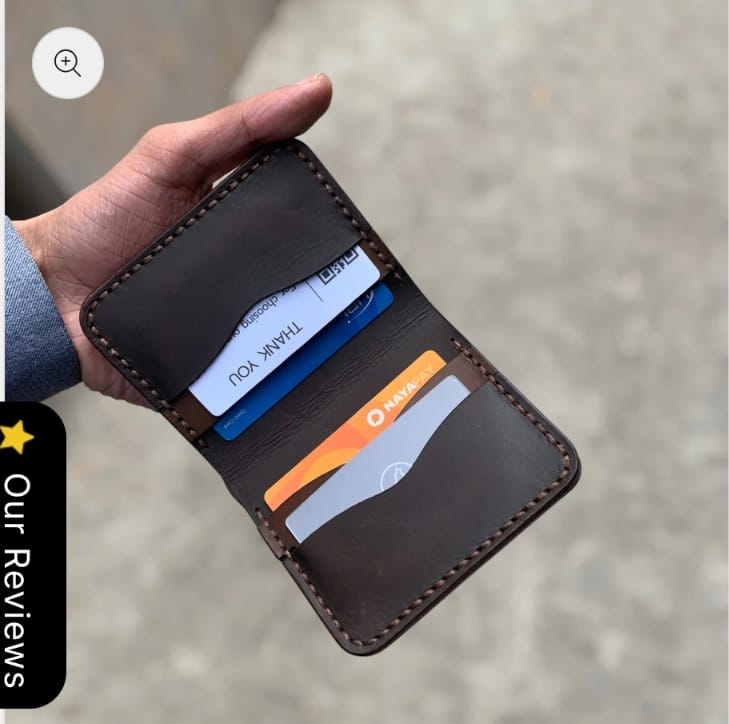 The Rancher Bifold Wallet open, holding cards and cash
